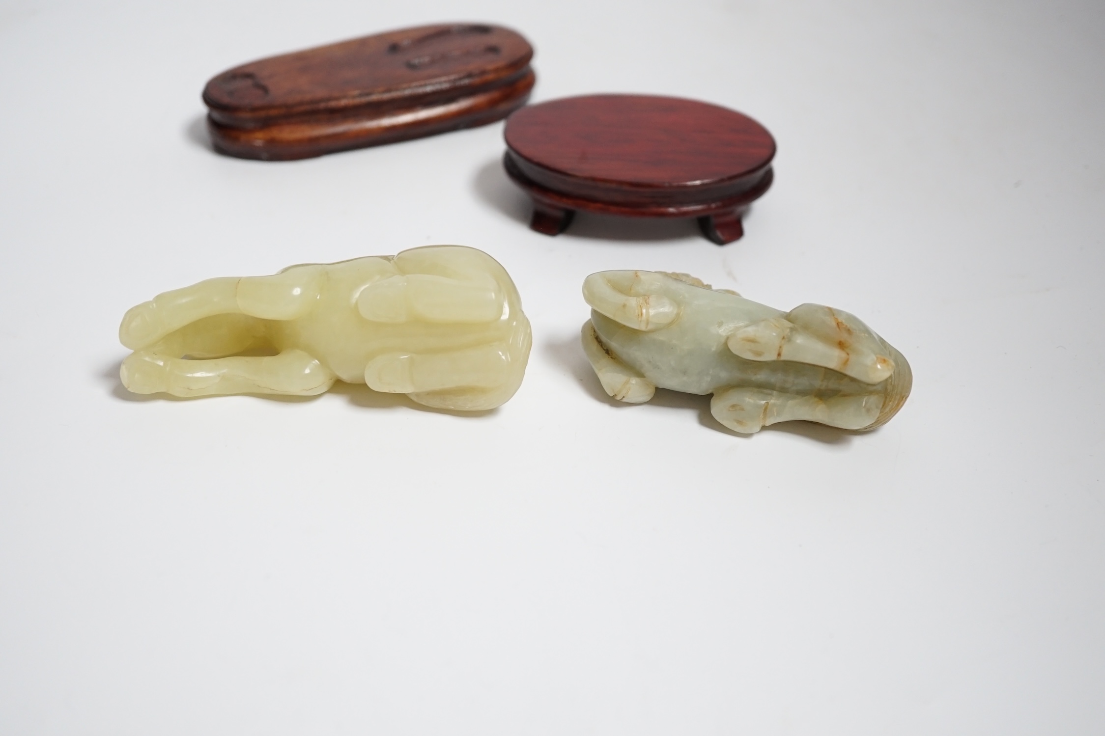 Two Chinese carved jade figures of horses on stands, largest 11cm wide